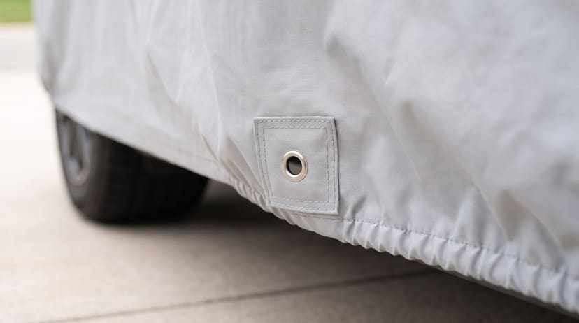 The elastic hem and a reinforced grommet on the edge of a light grey Lite cover