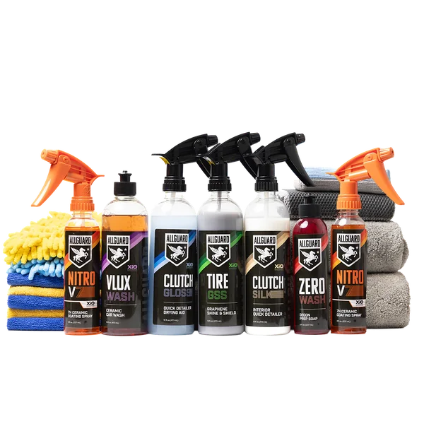 A row of AllGuard car care bottles with towels and a wash mitt.