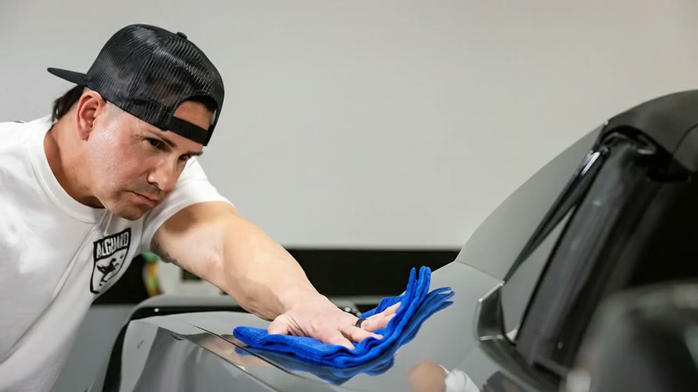 A microfiber cloth wiping down a clean painted body panel.