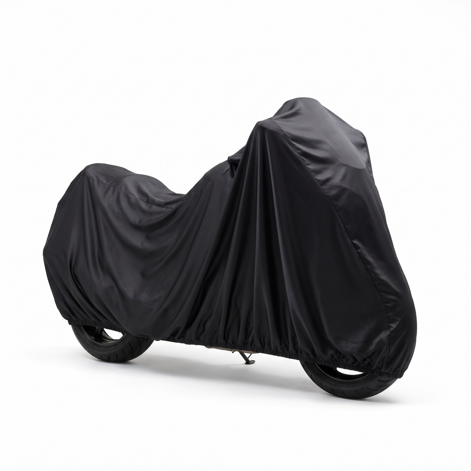 A motorcycle with a windscreen under a loosely draped black stretch cover on a white background.