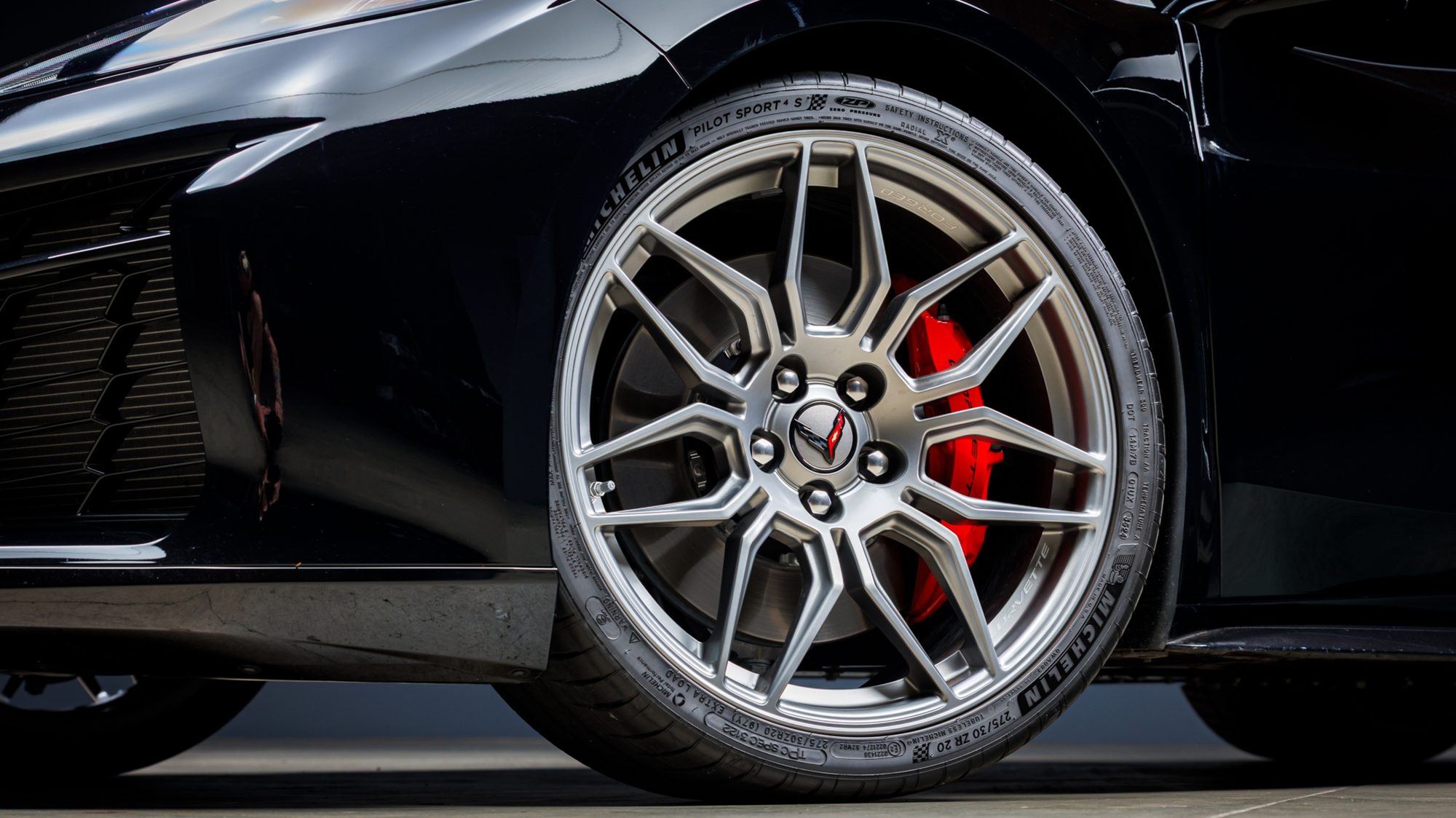 A close view of the Z06's forged wheel and red brake caliper stamped Corvette, with the Michelin Pilot Sport 4S tire's sidewall text visible