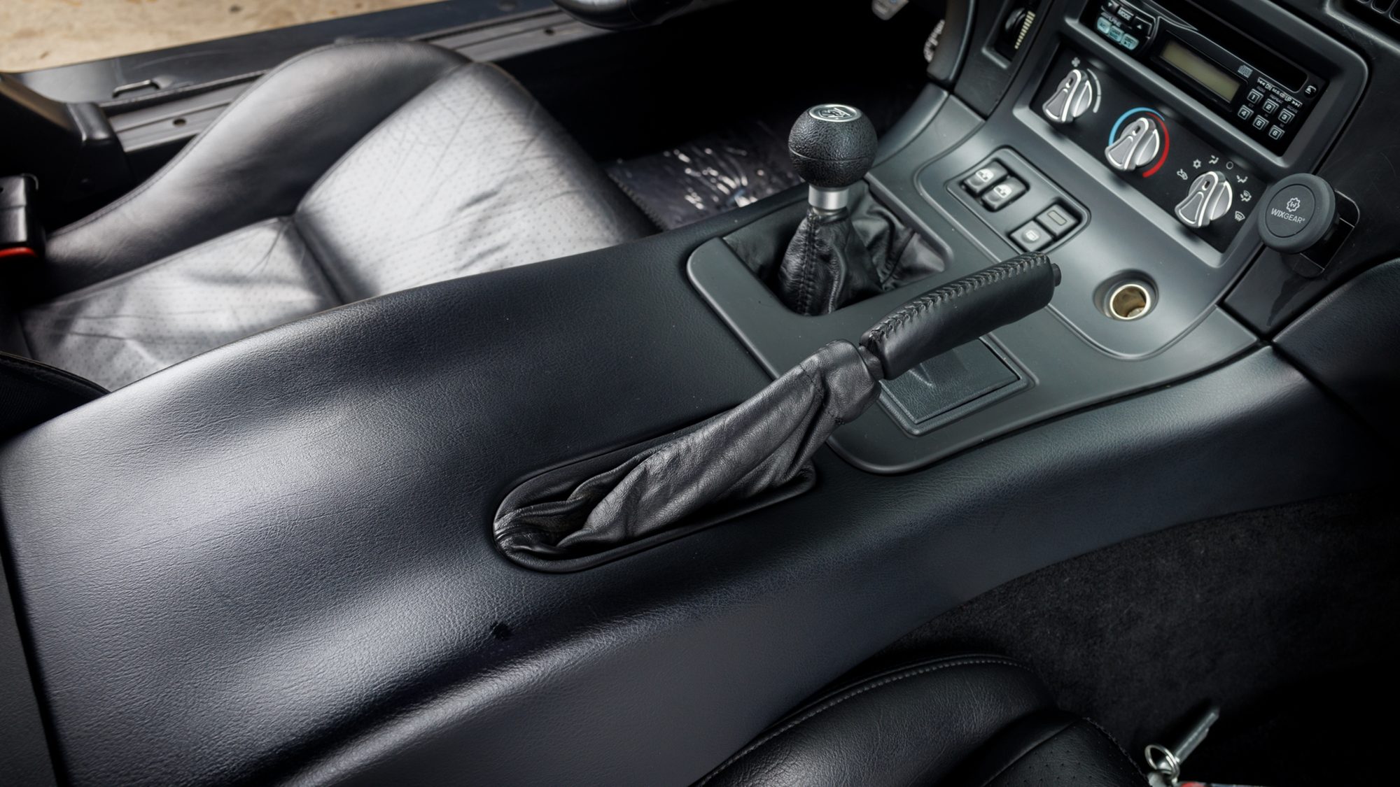 A close view of the Viper's center console, showing the round black shift knob for the manual transmission, a leather-booted parking brake handle, and the climate controls and switches beside it.
