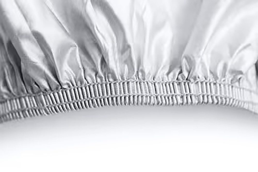 Close-up of a cover's gathered elastic hem and its stitched edge
