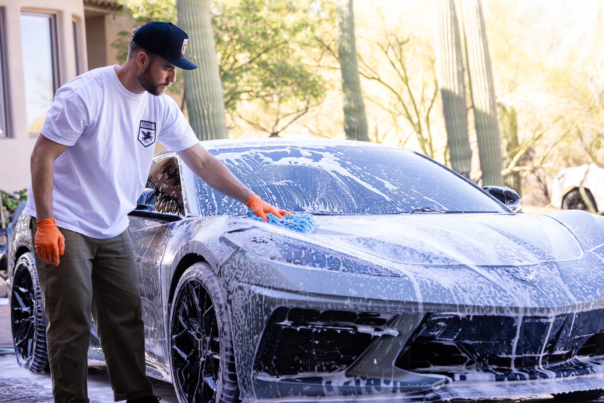A car being foam-washed in a driveway